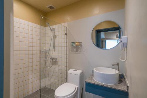 ein Badezimmer mit einem WC, einem Waschbecken und einem Spiegel in der Unterkunft The Blanket Hotel Phuket Old Town in Phuket