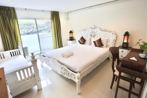 a bedroom with a white bed and a desk and a window at 39 Living in Bangkok
