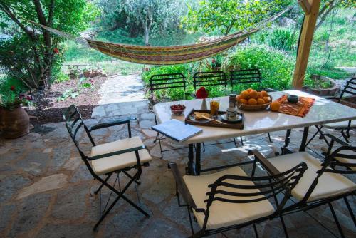 a patio with a table and chairs with a bowl of fruit at Aphrodite's Coast Retreat House! in Galaxidhion