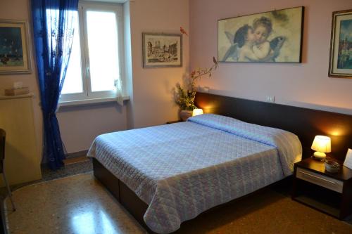 ローマにあるb&b A casa Gaddoのベッドルーム1室(ベッド1台、ランプ2つ、窓付)
