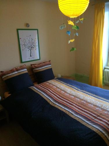 a bedroom with a bed with a blue comforter at Chambres d'hôtes Chez Epicure in Ballaigues