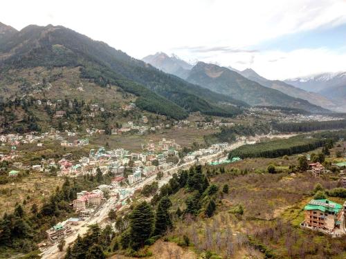 an aerial view of a town in the mountains at Hotel Mountain face by Snow City Hotels in Manāli