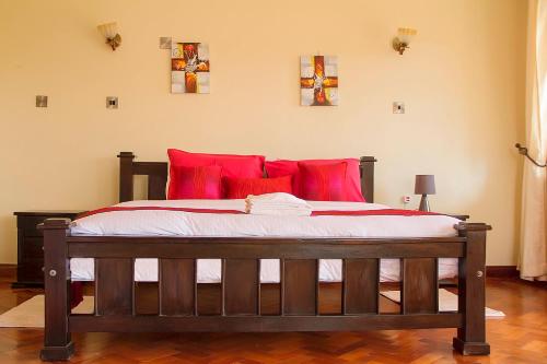 a bedroom with a large bed with red pillows at Orchid Homes, Gigiri in Nairobi