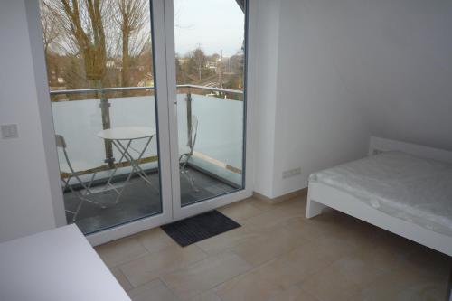 a room with a bed and a balcony with a table at Appartement mit Aussicht in Mülheim an der Ruhr