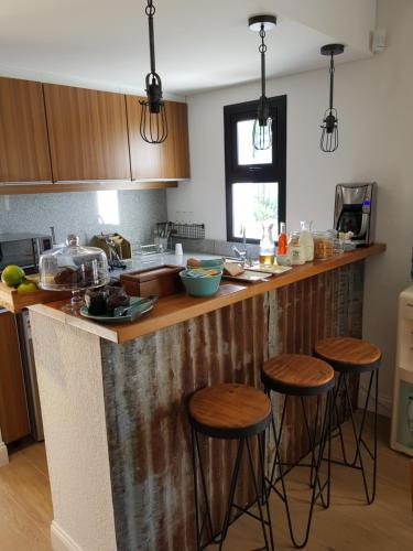 a kitchen with wooden counter tops and bar stools at Pizzorno Lodge & Wine in Progreso