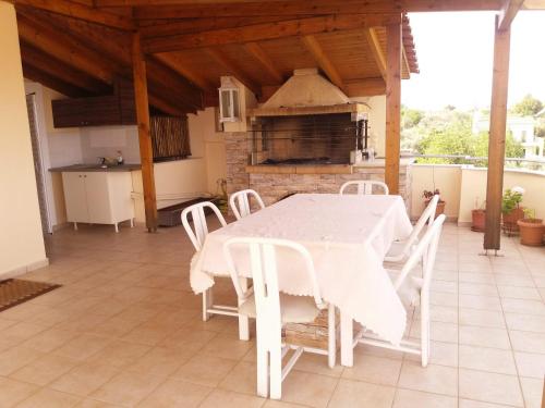 uma mesa branca e cadeiras numa cozinha em House with Wonderful View em Cálcis