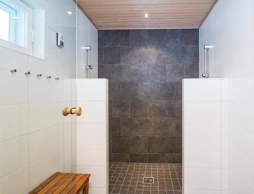 a bathroom with a shower with a bench in it at Villa Puolukka in Tahkovuori