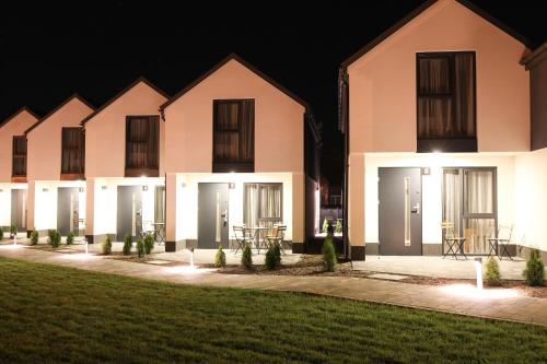 a large white building with doors at night at Pina House in Rewal