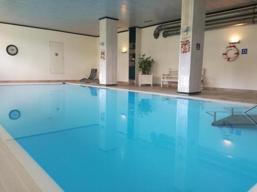a large swimming pool with blue water at Wellnessapartment Alpenland Top 22 in Seefeld in Tirol