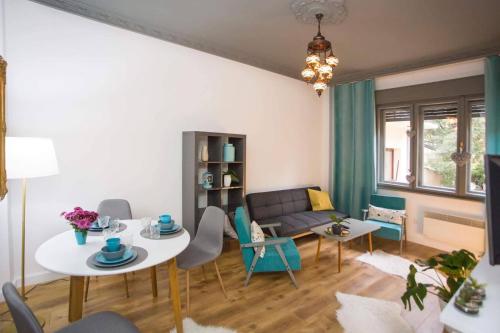 a living room with a couch and a table and chairs at Flamingos Apartment ★ Free Parking ★ City Center ★ in Novi Sad