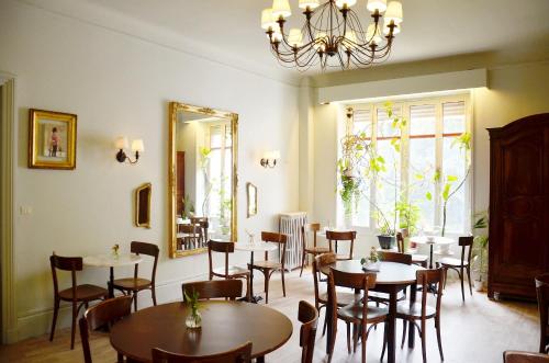 comedor con mesas, sillas y espejo en Saint Charles Hôtel & Coliving Biarritz, en Biarritz