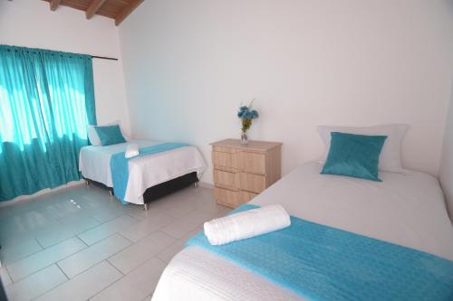 una camera da letto con due letti, un comò e una finestra di apartamentos amoblados casa margarita laureles estadio excelente ubicación a Medellín