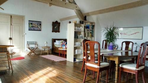 a living room with a dining room table and chairs at La Maison de l'Escargot in Seigny