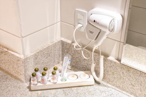 a hair dryer and a phone in a bathroom at Rodoserv Hotel in Pardinho