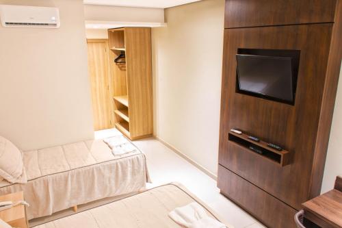 a living room with a couch and a tv in a room at Rodoserv Hotel in Pardinho