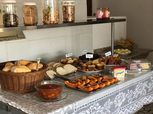 a buffet with many different types of bread and pastries at Pousada Santa Rosa in Aparecida
