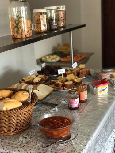 a table topped with baskets of bread and other food at Pousada Santa Rosa in Aparecida