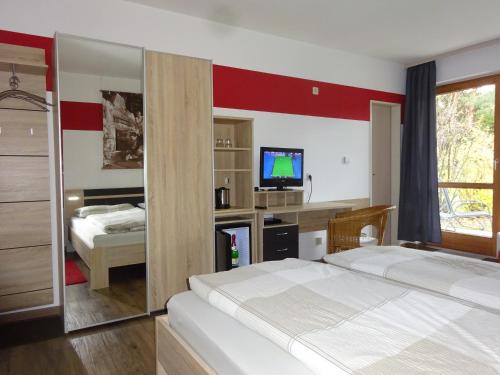 um quarto de hotel com duas camas e uma televisão em Gästehaus Sonneck em Bischofsgrün