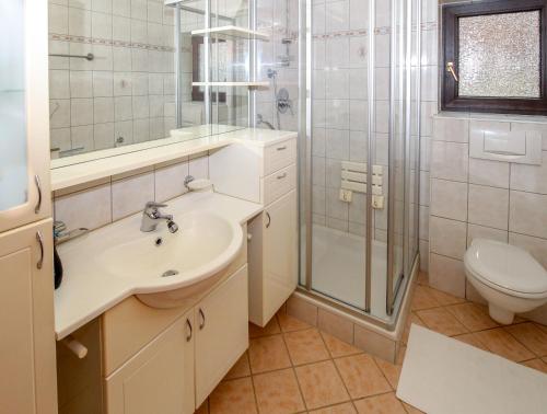 a bathroom with a sink and a shower and a toilet at Ferienwohnung Stoff in Tux