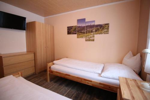 a small bedroom with two beds and a tv at Ferienwohnung Stoff in Tux