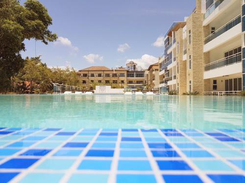 una piscina con acqua blu di fronte agli edifici di Koko and Suzy's ocean dream a Laguna del Higüero