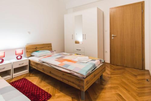 a bedroom with a large bed and a wooden floor at Apartments "Pavić" near Zagreb Airport in Velika Gorica