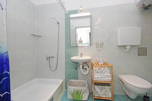 y baño con lavabo, aseo y ducha. en Villa Igrane, en Igrane