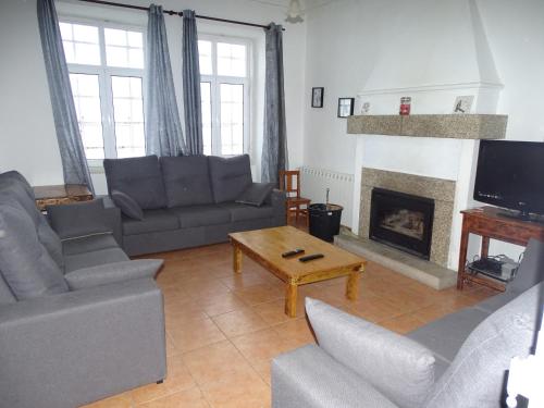 a living room with couches and a fireplace at Penhas da Saúde in Penhas da Saúde