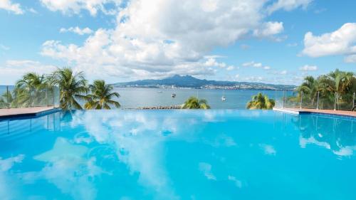 レ・トロワ・イレにあるHotel Bakoua Martiniqueの水辺の景色を望む大型スイミングプール