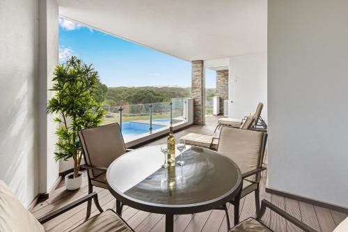 a dining room with a table and chairs on a balcony at Luxurious T2 apartment, Olhos Dagua in Albufeira