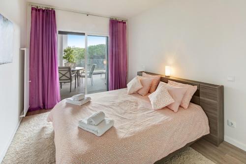 - une chambre avec un lit et 2 serviettes dans l'établissement Luxurious T2 apartment, Olhos Dagua, à Albufeira