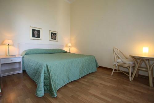 a bedroom with a bed and a table with a chair at Hotel Duomo in Siena