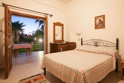 a bedroom with a bed and a door to a patio at Glaro Garden Hotel in Rizokarpaso
