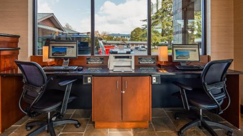 a desk with three computers on top of it at Best Western New Oregon Motel in Eugene
