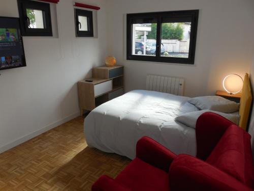 トゥールーズにあるRoom in Toulouse Studio 4 proche Airbus à TOULOUSE ST Martin du Touchのベッドルーム1室(ベッド1台、赤い椅子付)