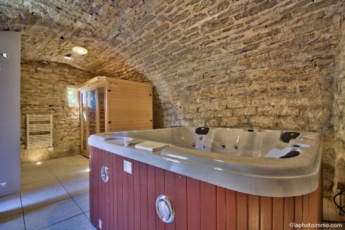 La salle de bains est pourvue d'une baignoire dans un mur en pierre. dans l'établissement Les Bouc'tins, à Molain