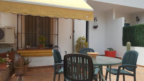 a patio with a table and chairs and a window at CASA HACIENDA EL OLIVAR in El Bosque