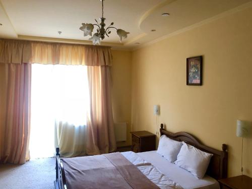 a bedroom with a bed and a large window at Chervona Gora in Mukacheve