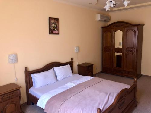 a bedroom with a bed with white sheets and a dresser at Chervona Gora in Mukacheve