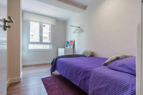 バレンシアにあるCedro flatのベッドルーム(紫色のベッド1台、窓付)