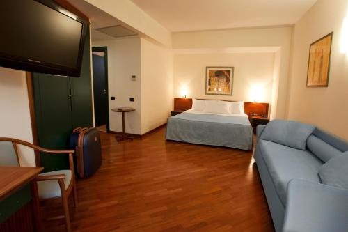 a hotel room with a bed and a couch at Grande Albergo Maugeri in Acireale