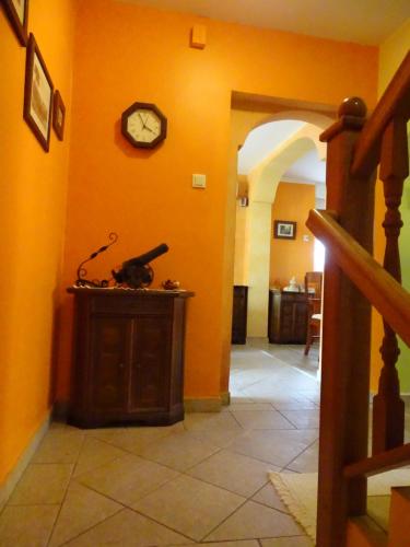 a hallway with an orange wall with a clock on it at Sobe-Apartma in Maribor