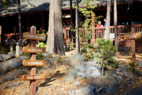 a garden with wooden signs in front of a house at Evergreen Lodge at Yosemite in Groveland