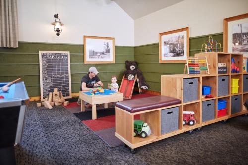 a room with a woman sitting at a table with toys at Evergreen Lodge at Yosemite in Groveland