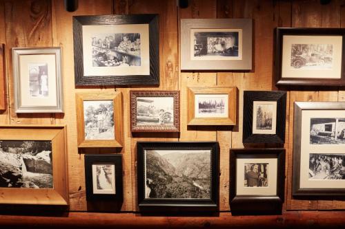 a wall full of framed photographs on a wall at Evergreen Lodge at Yosemite in Groveland
