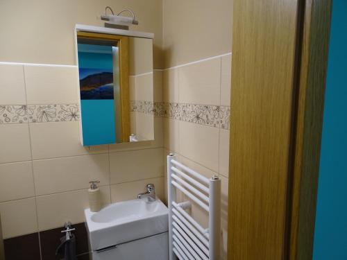a bathroom with a sink and a mirror at Sobe-Apartma in Maribor