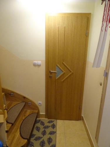 a room with a wooden door and a table and chairs at Sobe-Apartma in Maribor