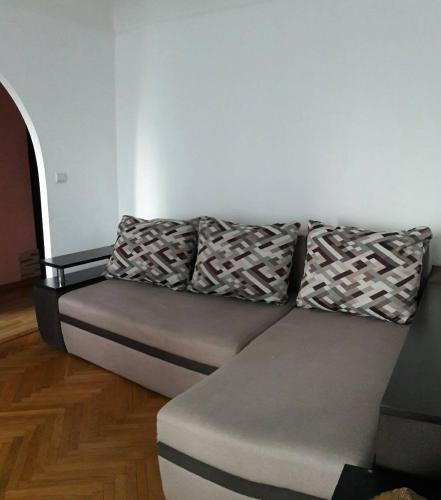 a grey couch with two pillows on top of it at 3- х комнатная квартира в центре in Rivne