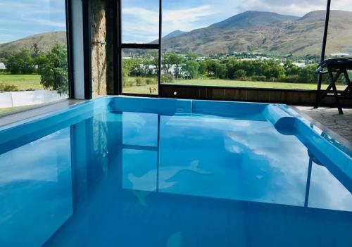una piscina de agua azul y montañas de fondo en Hotel San Luis Sachica, en Sáchica