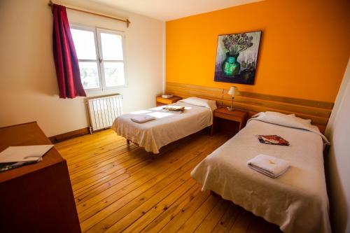 a hotel room with two beds and a window at South B&B El Calafate in El Calafate